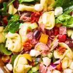 Close up of this tortellini pasta salad in a wooden salad bowl