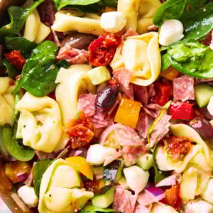 Close up of this tortellini pasta salad in a wooden salad bowl