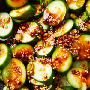 Overhead photos of scallions, sesame, chili, and soy sauce top Asian Cucumber Salad.