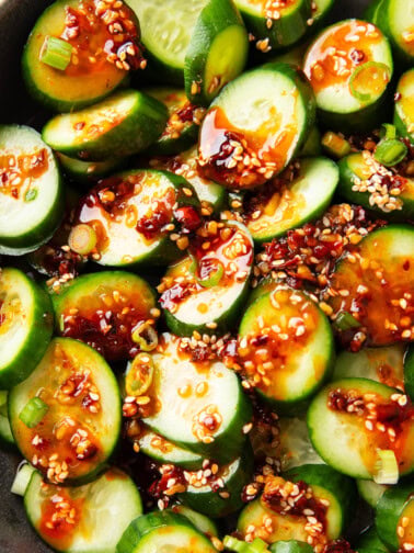 Overhead photos of scallions, sesame, chili, and soy sauce top Asian Cucumber Salad.