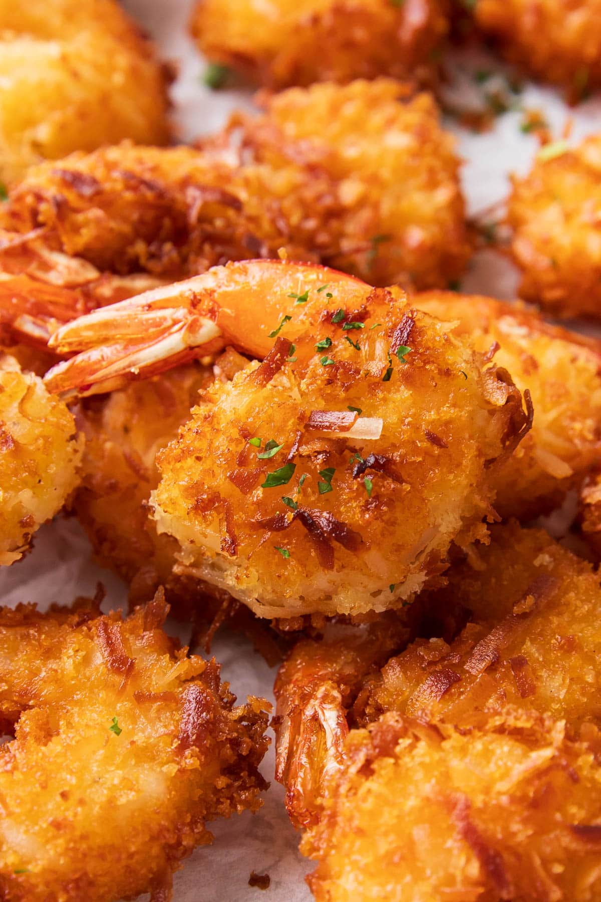 Close up of this easy coconut shrimp recipe showing golden flakes of coconut and breadcrumbs.