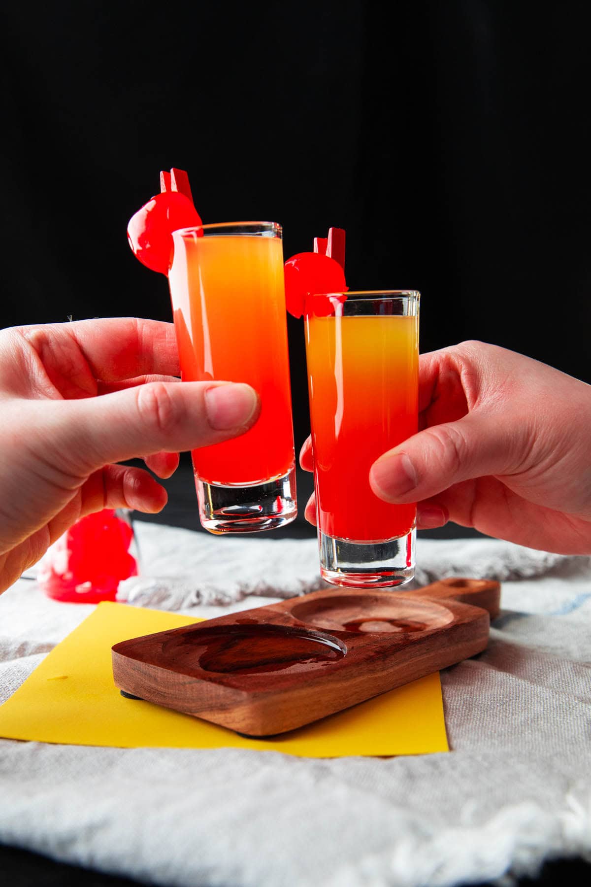 Two people toasting with vodka-infused dessert shooters.
