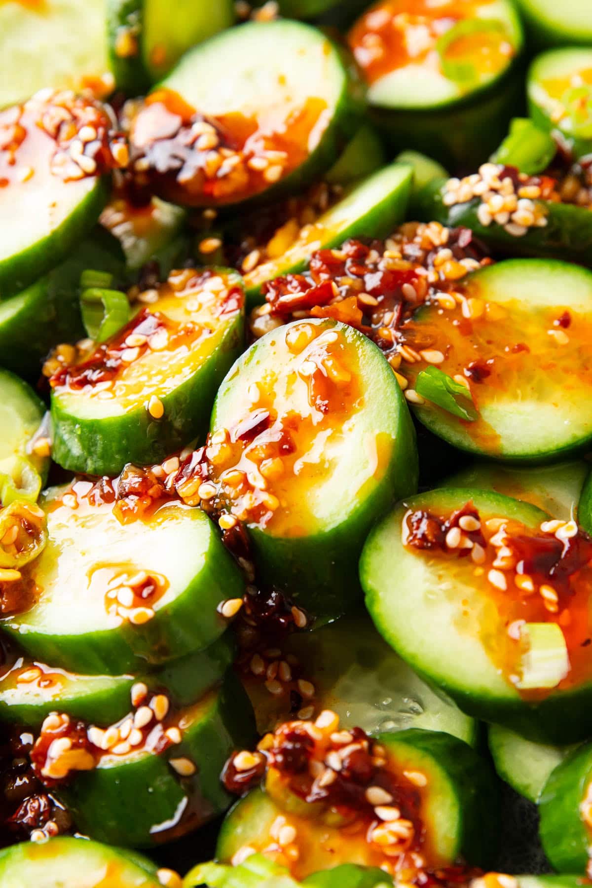 Close up of sesame and chili infused rice vinegar dressing poured over this Asian cucumber salad.