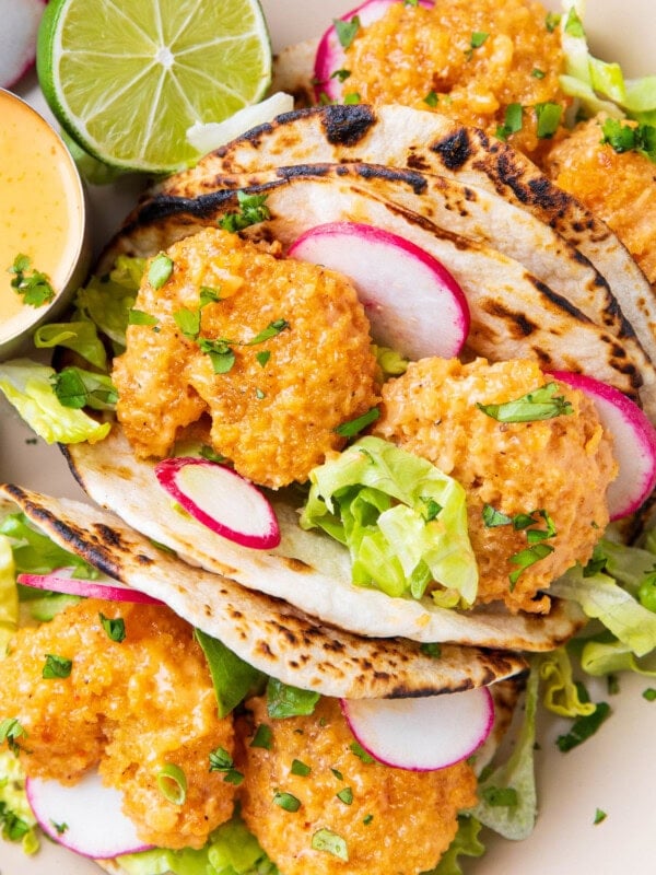 this bang bang taco recipe includes generously sauced shrimp is tucked in a charred taco with fresh lettuce, a squeeze of lime, and lots of bang bang sauce