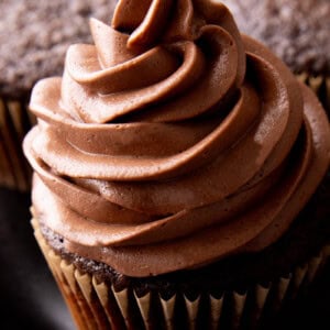close up of creamy chocolate frosting on top of a cupcake