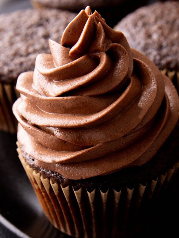 close up of creamy chocolate frosting on top of a cupcake