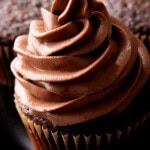 Close up of rich chocolate frosting that's homemade and made with cocoa powder piped on a cupcake.