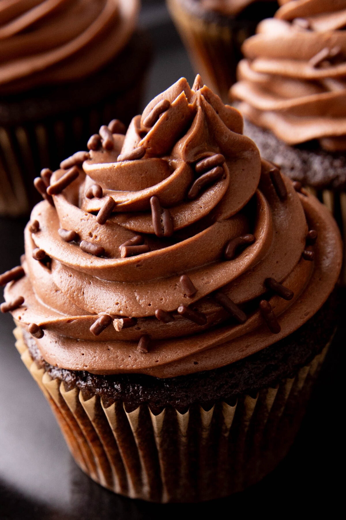 close up of rich chocolate frosting on a cupcake