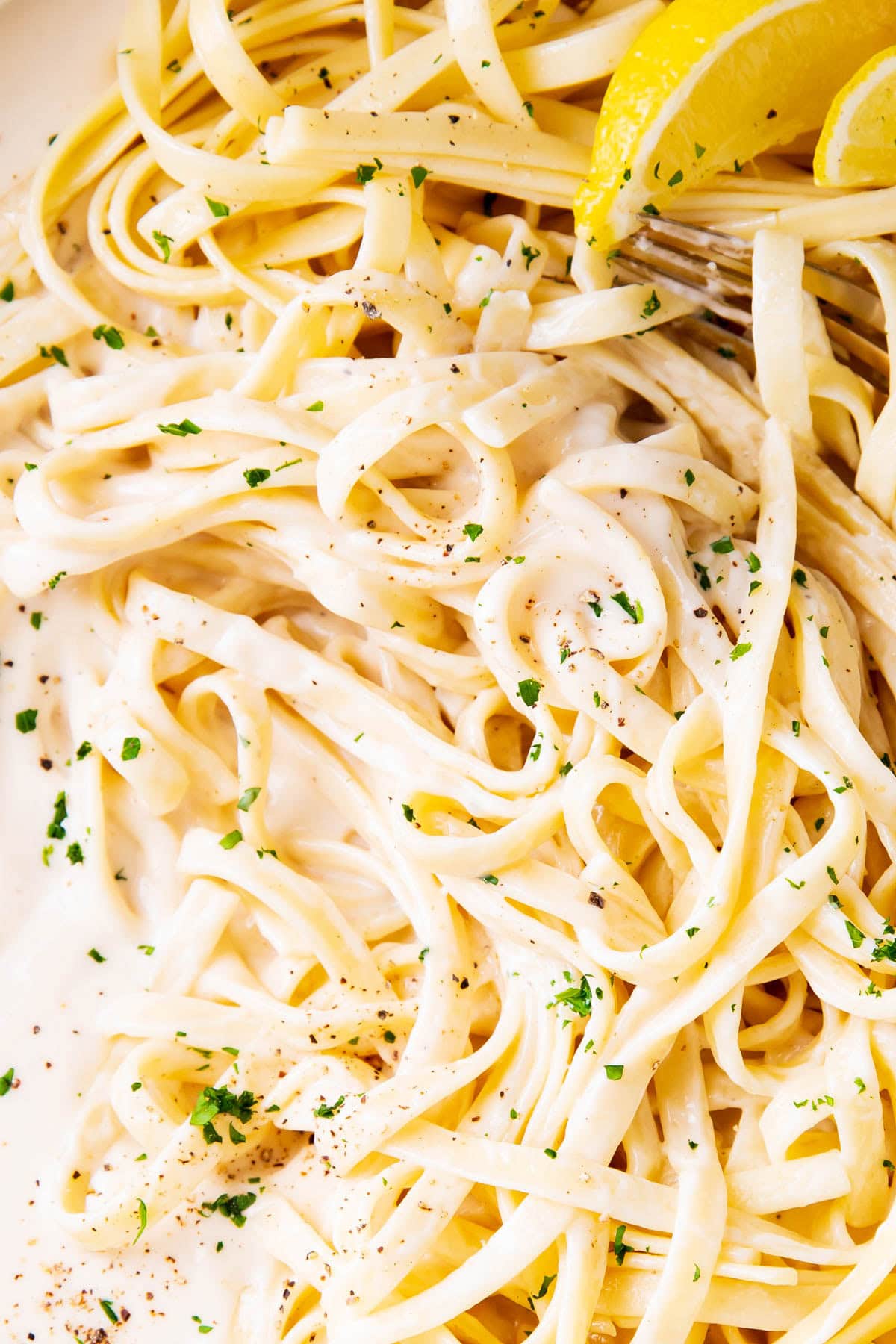 Close up of this easy fettuccine Alfredo to show perfectly cooked fettuccine pasta and homemade sauce coating everything