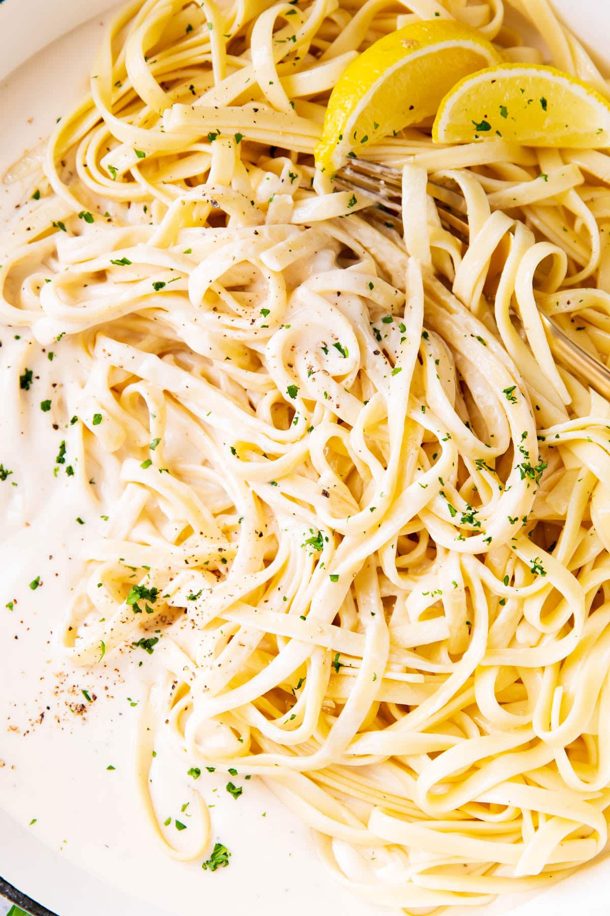 The best fettuccine Alfredo recipe includes a heavy cream and parmesan based pasta sauce with lots of fettuccine garnished with parsley