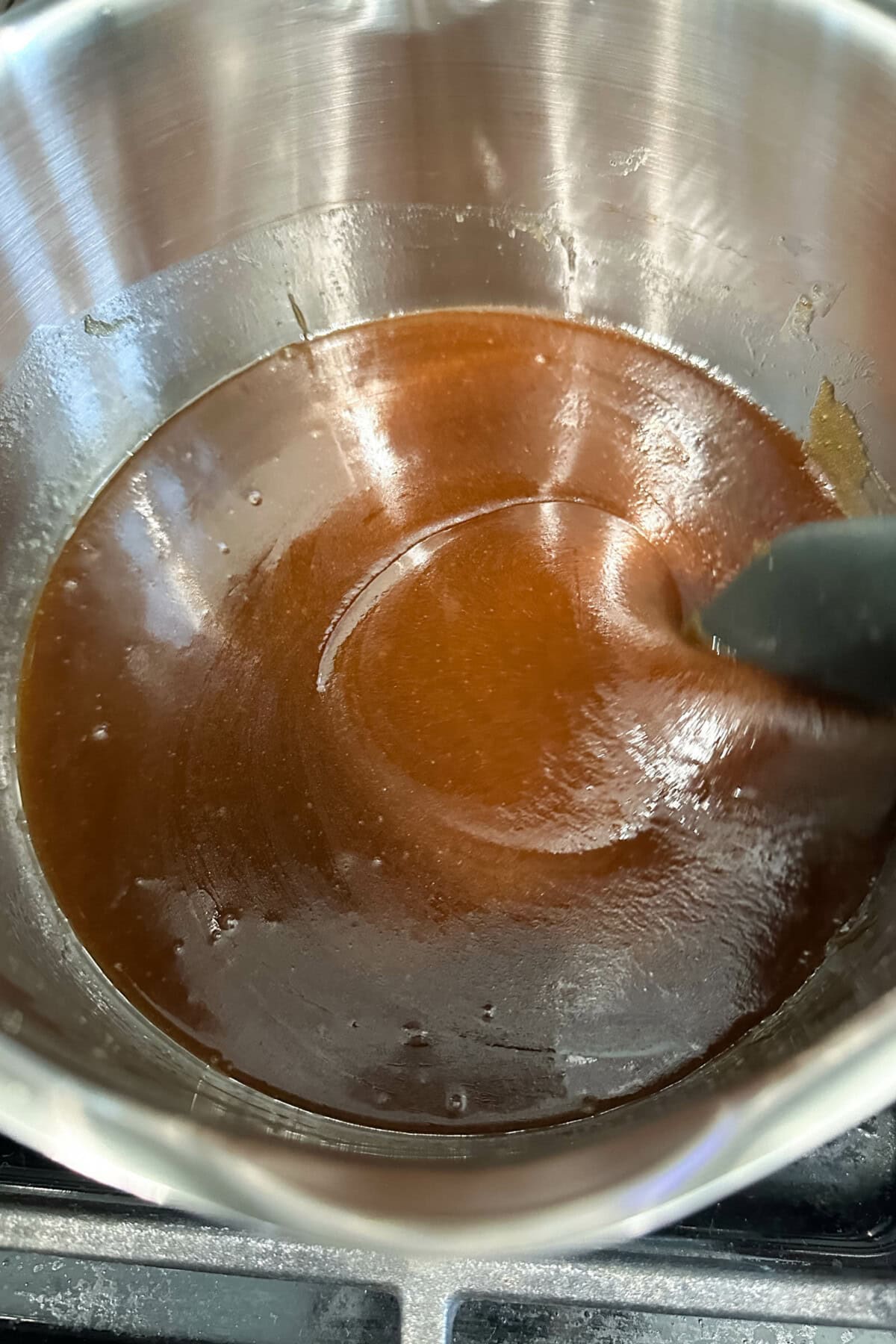 Cooking the brown sugar butter glaze on the stovetop - make sure it's one cohesive liquid as shown in the photo for well glazed monkey pull apart bread