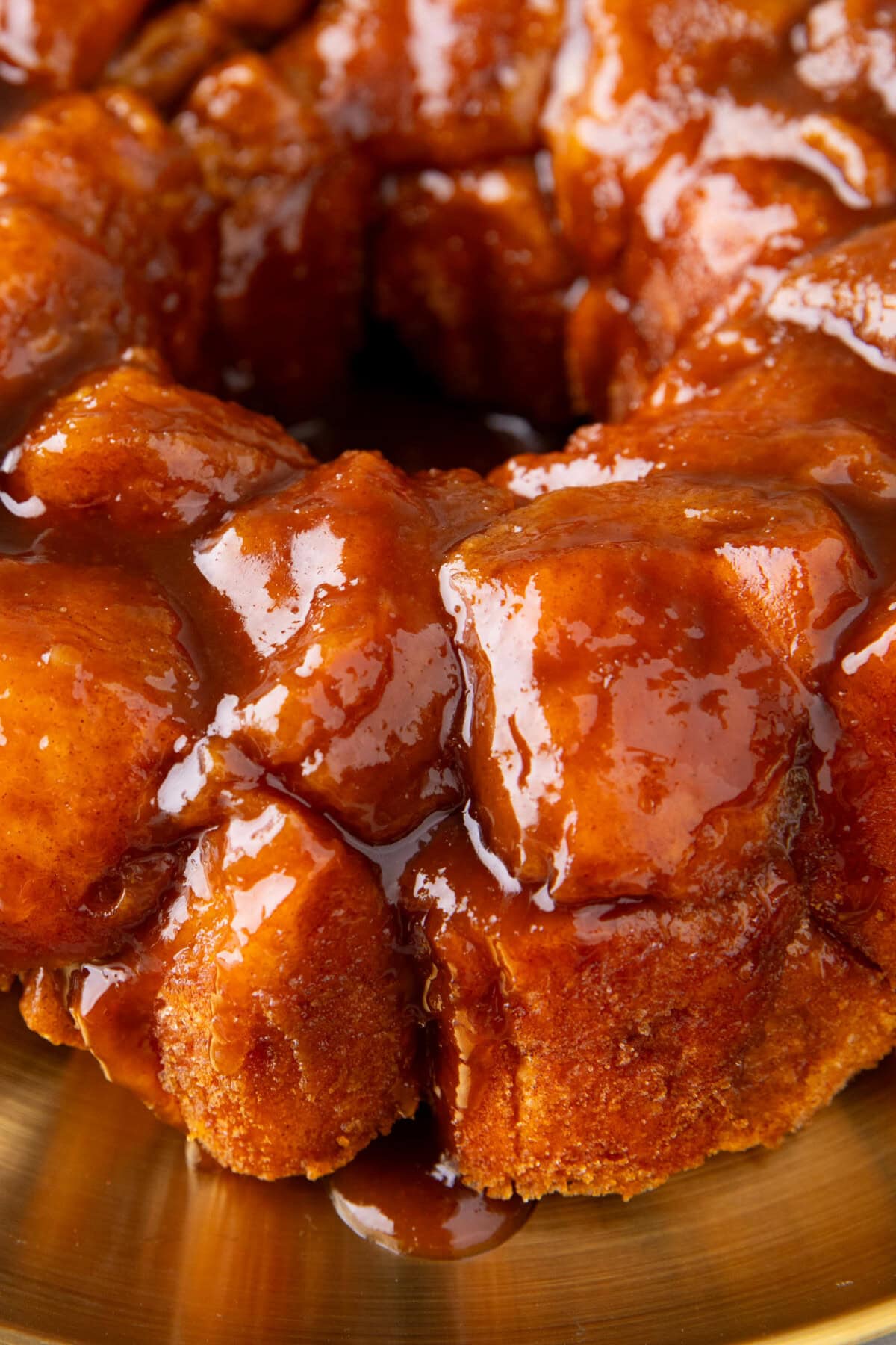 close up of the sweet cinnamon sugar butter glaze that coats individual biscuit pieces in this easy monkey bread