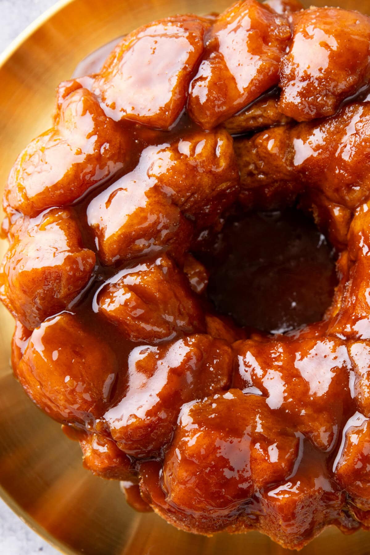 overhead photo of monkey bread to show the sticky glaze coating a ring of cinnamon sugar pullapart biscuit pieces