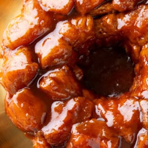 overhead photo of monkey bread to show the sticky glaze coating a ring of cinnamon sugar pullapart biscuit pieces
