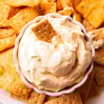 Pumpkin Fluff Dip is fluffy and airy with a whipped texture served in a bowl with graham crackers and sprinkled with pumpkin pie spice
