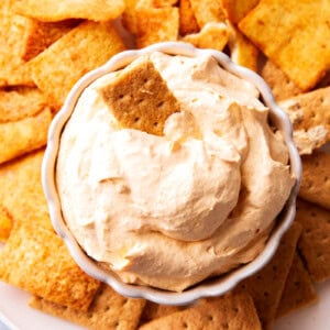 Pumpkin Fluff Dip is fluffy and airy with a whipped texture served in a bowl with graham crackers and sprinkled with pumpkin pie spice