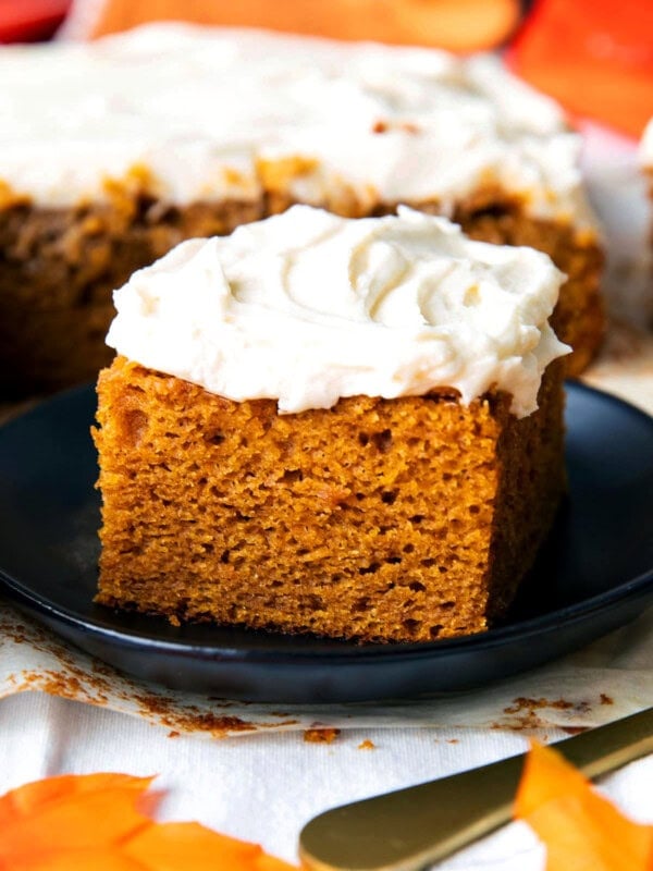 Close up of a slice of this pumpkin spice cake with cream cheese frosting to show soft and moist crumb with rich frosting