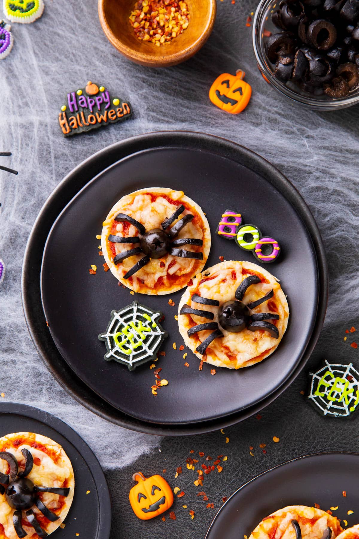Halloween pizza served on a plate with Halloween party decorations