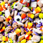 close up of Halloween puppy chow recipe to show crunchy Chex mix cereal coated in peanut butter, powdered sugar and chocolate.