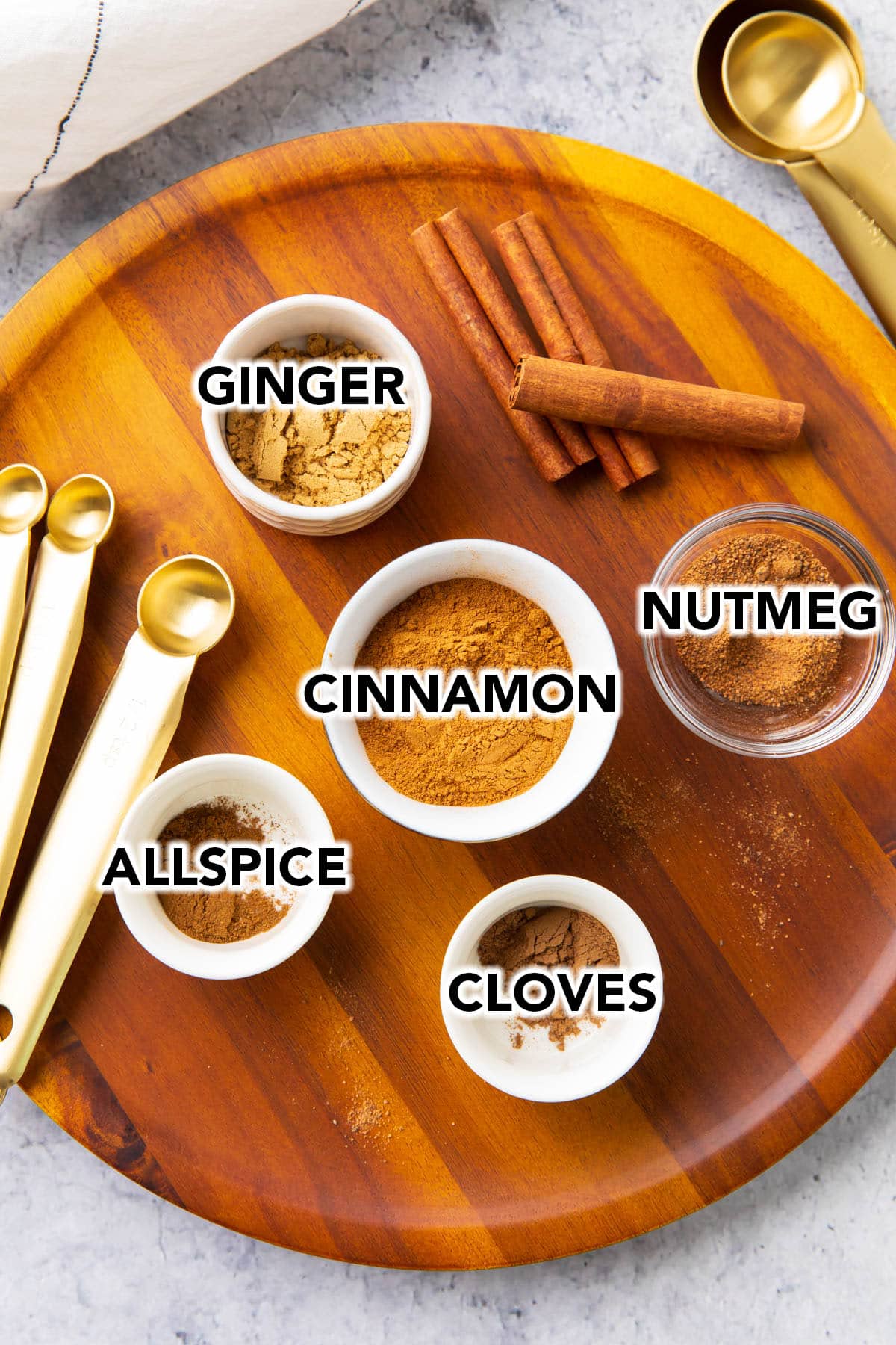 Substitute spice for pumpkin pie spice pre-measured into bowls including ground cinnamon, cloves, ginger, allspice, and nutmeg.