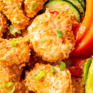 Close up of bang bang shrimp recipe easy shows crisp fried shrimp coated in bang bang sauce.