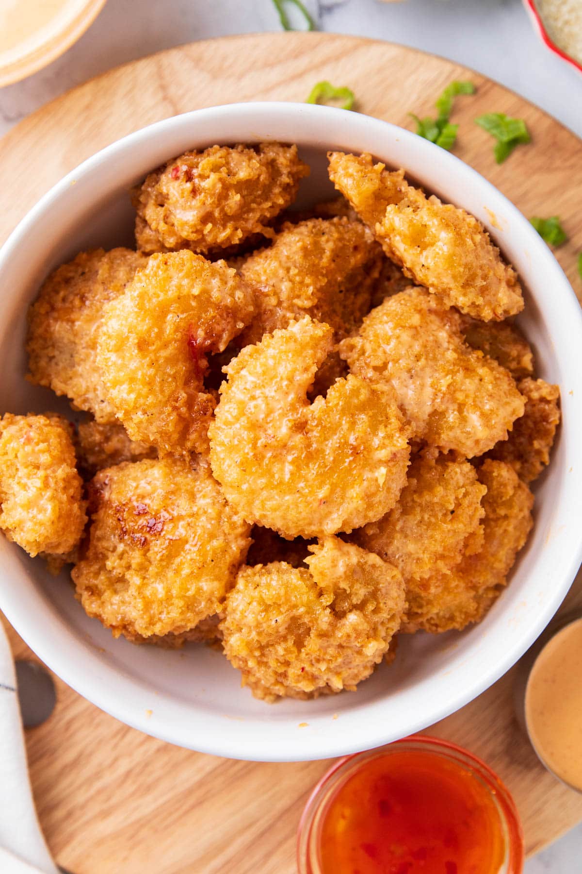 Serving bang bang shrimp recipe from Bonefish Grill in a bowl with thai sweet chili sauce and scallions on the side.