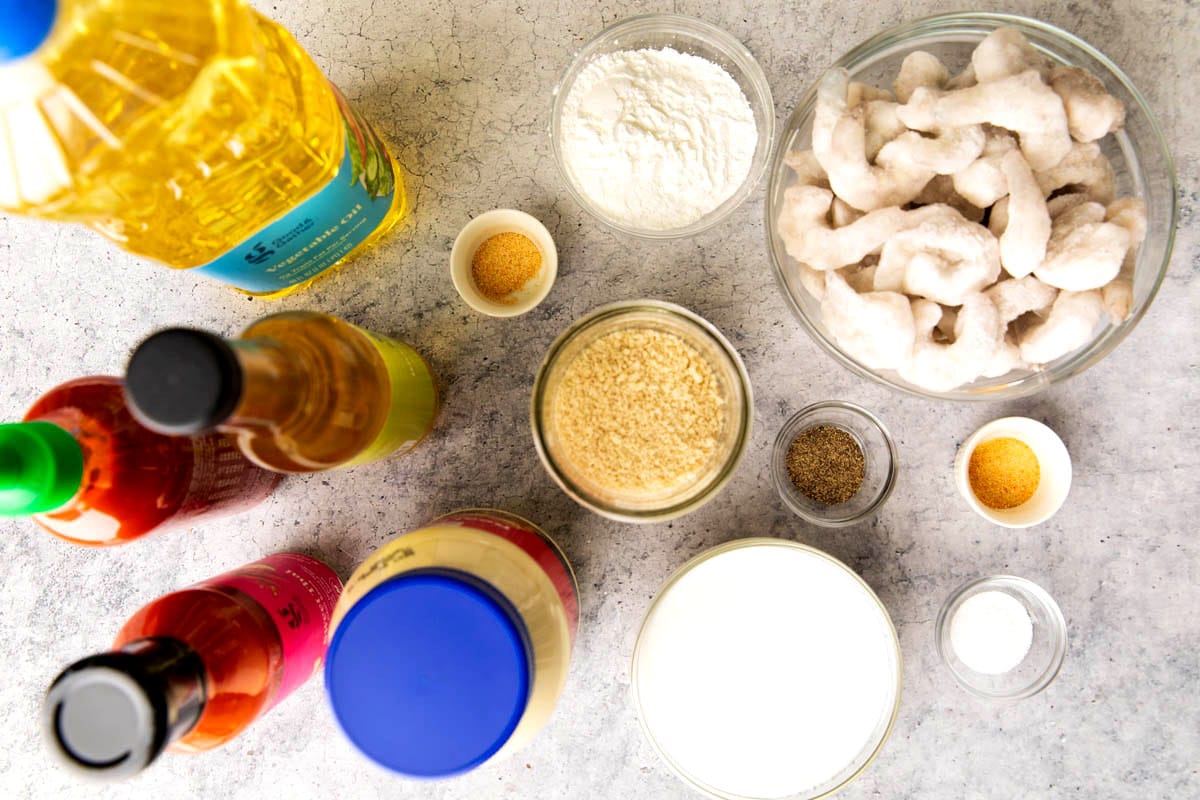 Copycat bang bang shrimp ingredients in prep bowls - mayonnaise, thai sweet chili sauce, sriracha, rice vinegar, shrimp, buttermilk, Panko and more.