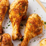 Close up of Cajun chicken drumsticks show golden skin coated with Cajun seasoning