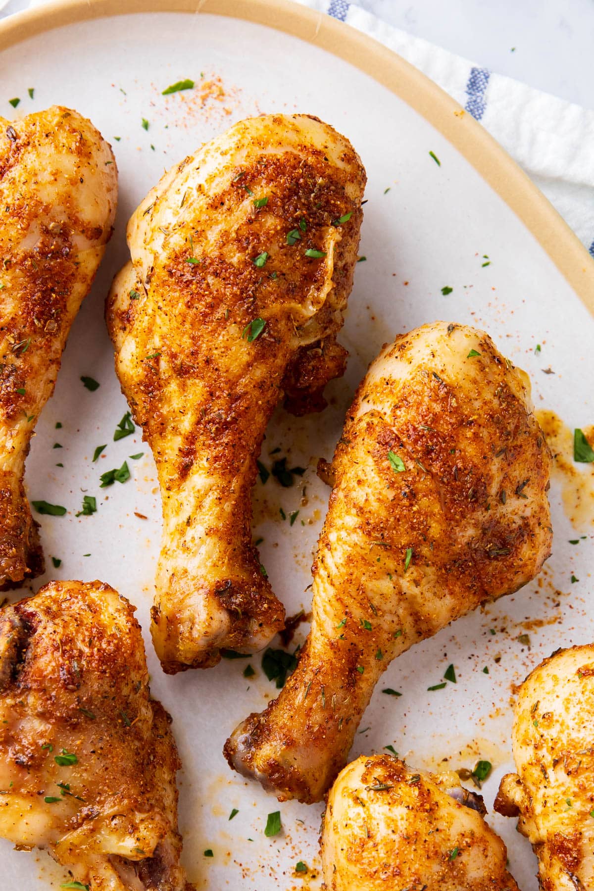 Close up of Cajun chicken drumsticks show golden skin coated with Cajun seasoning.