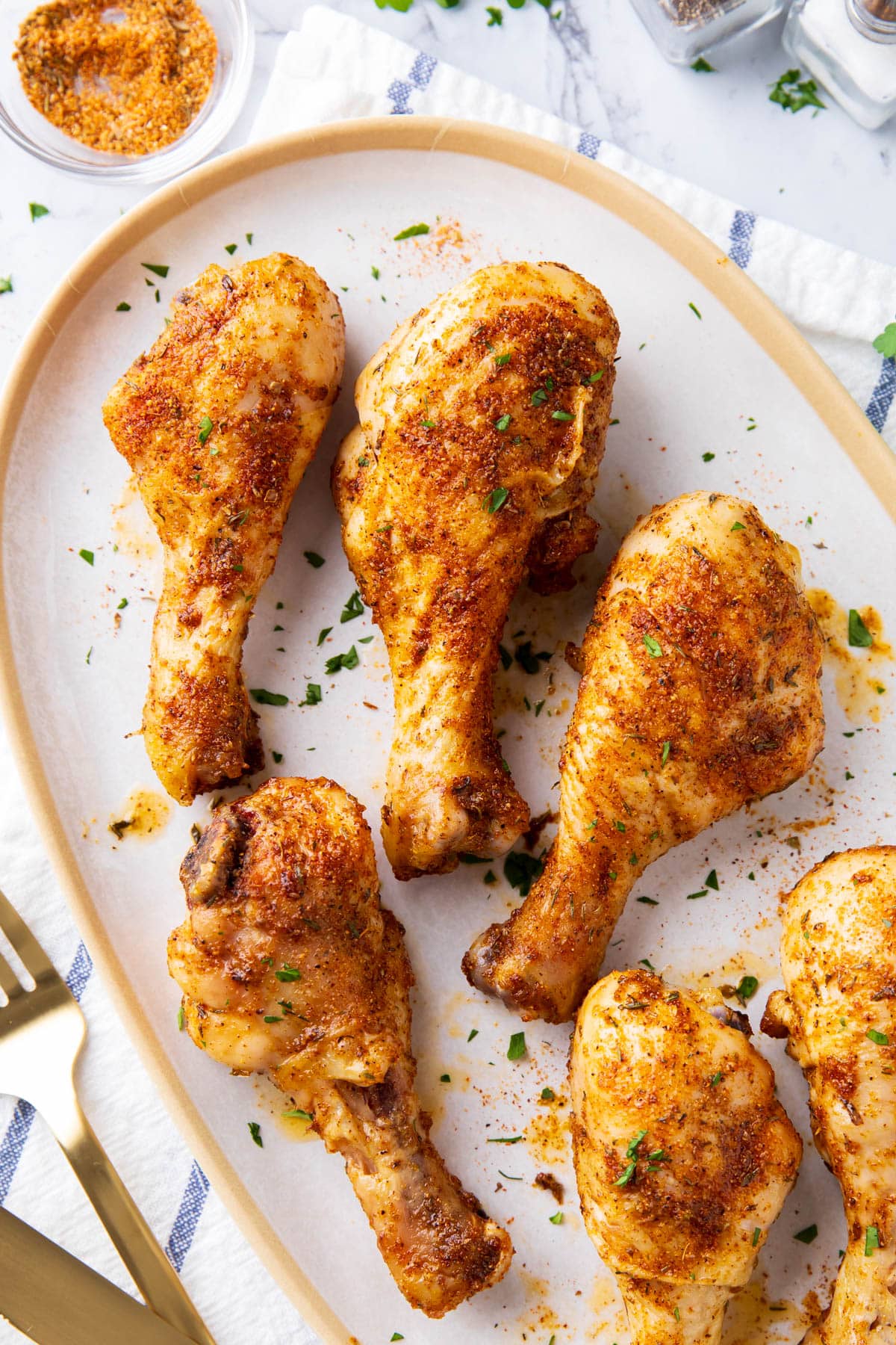 Oven baked chicken drumsticks are coated in butter and tossed in spicy Cajun seasoning for a bold, flavorful easy chicken dinner.