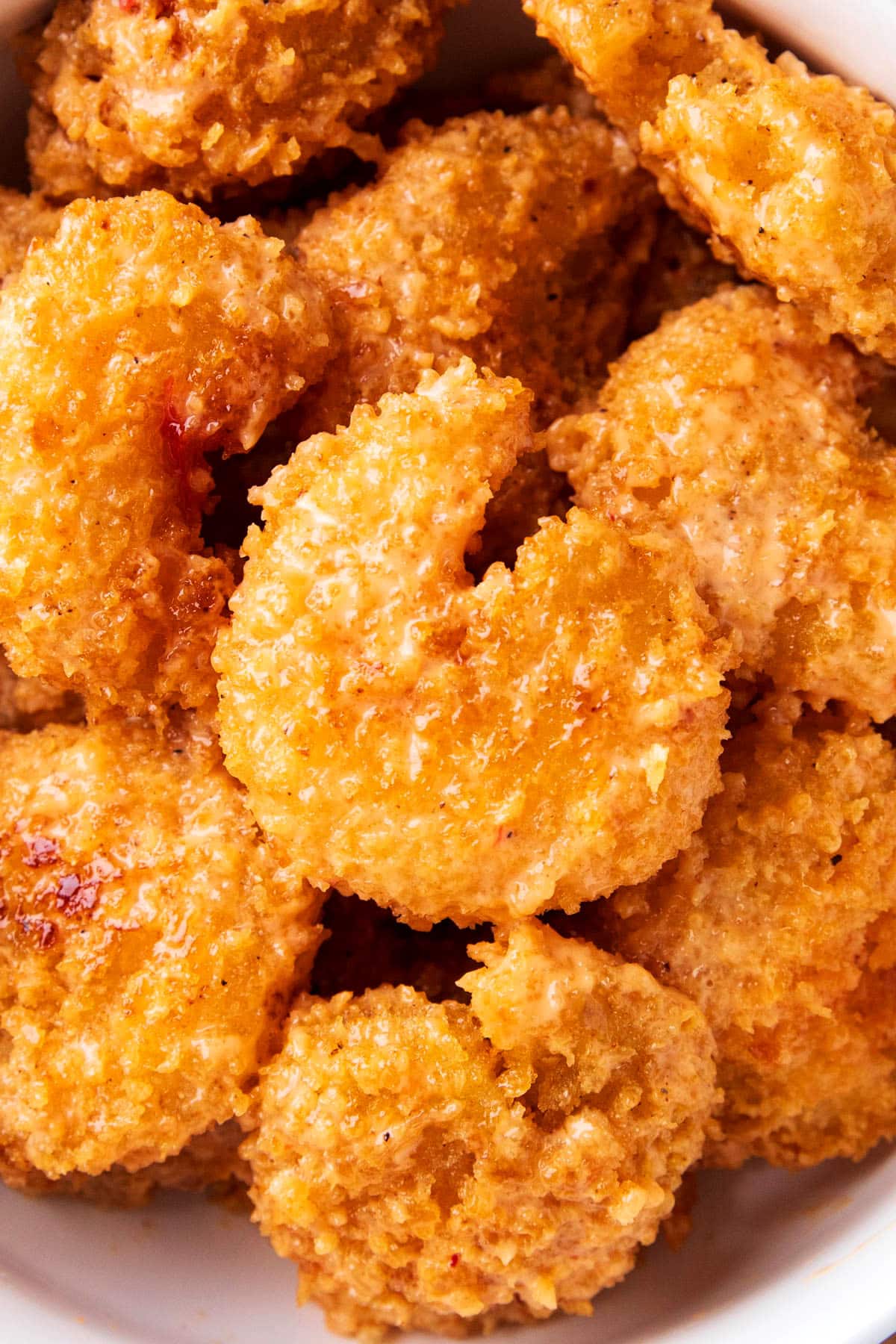 Close up of easy bang bang shrimp shows crisp fried shrimp coated in bang bang sauce.