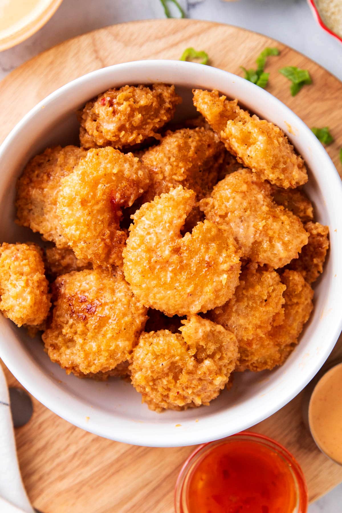 Serving the best bang bang shrimp recipe in a bowl with Thai sweet chili sauce and scallions on the side.
