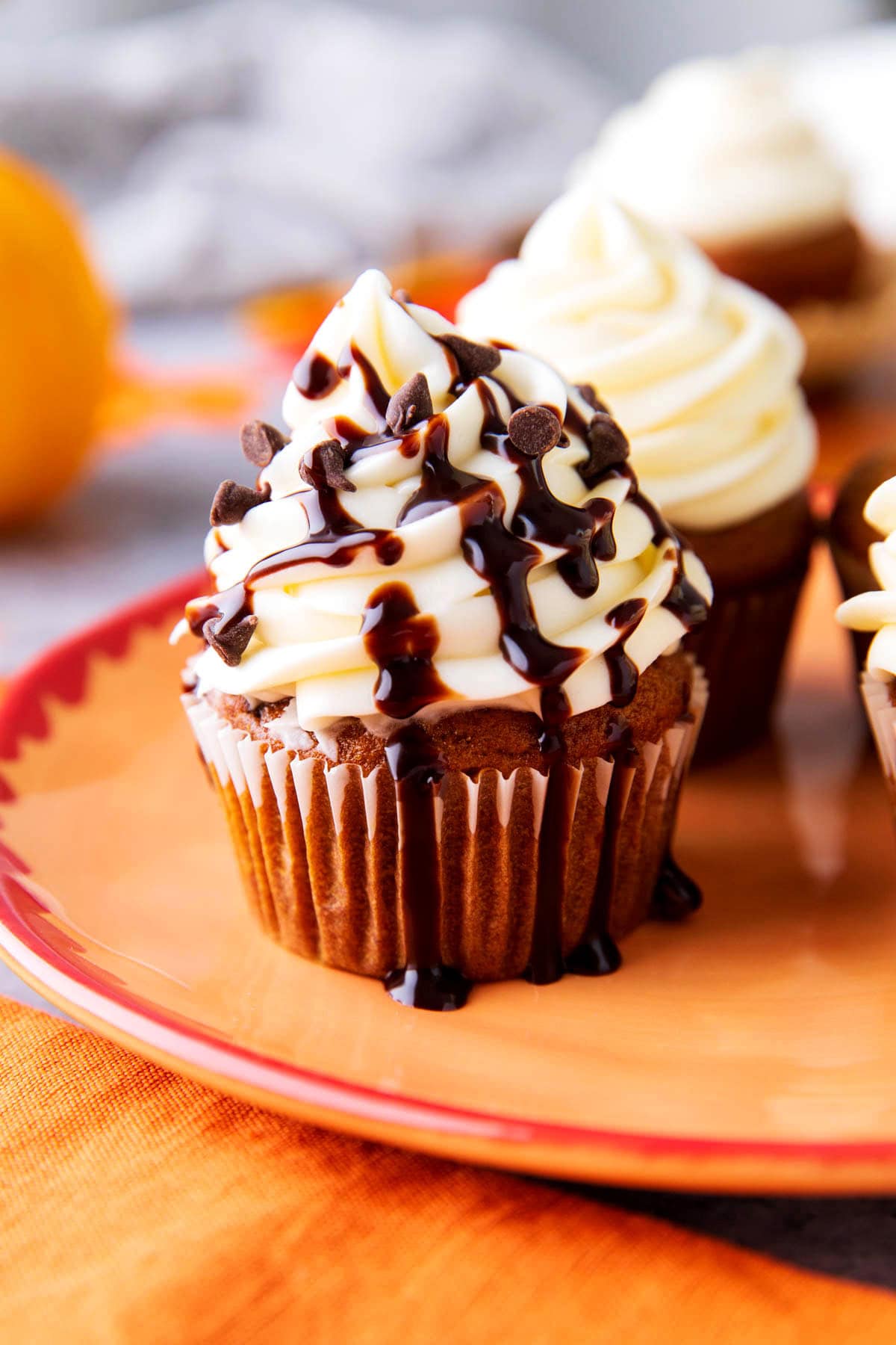 Tender and moist pumpkin chocolate chip cupcakes are served on a fall dessert platter.