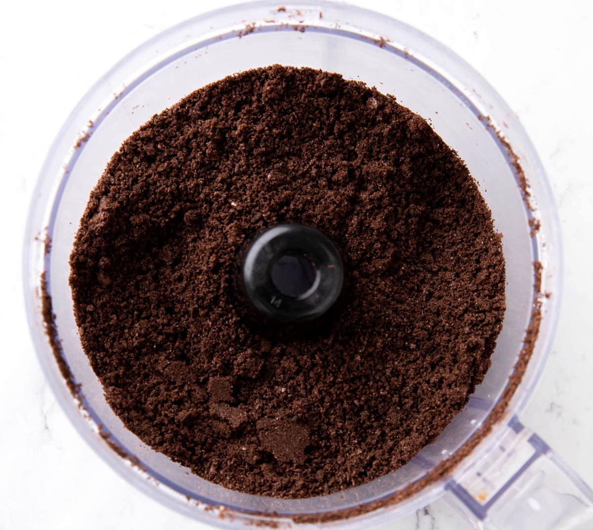 One photo showing How to Make Oreo Balls - crushed Oreo cookies in a food processor.