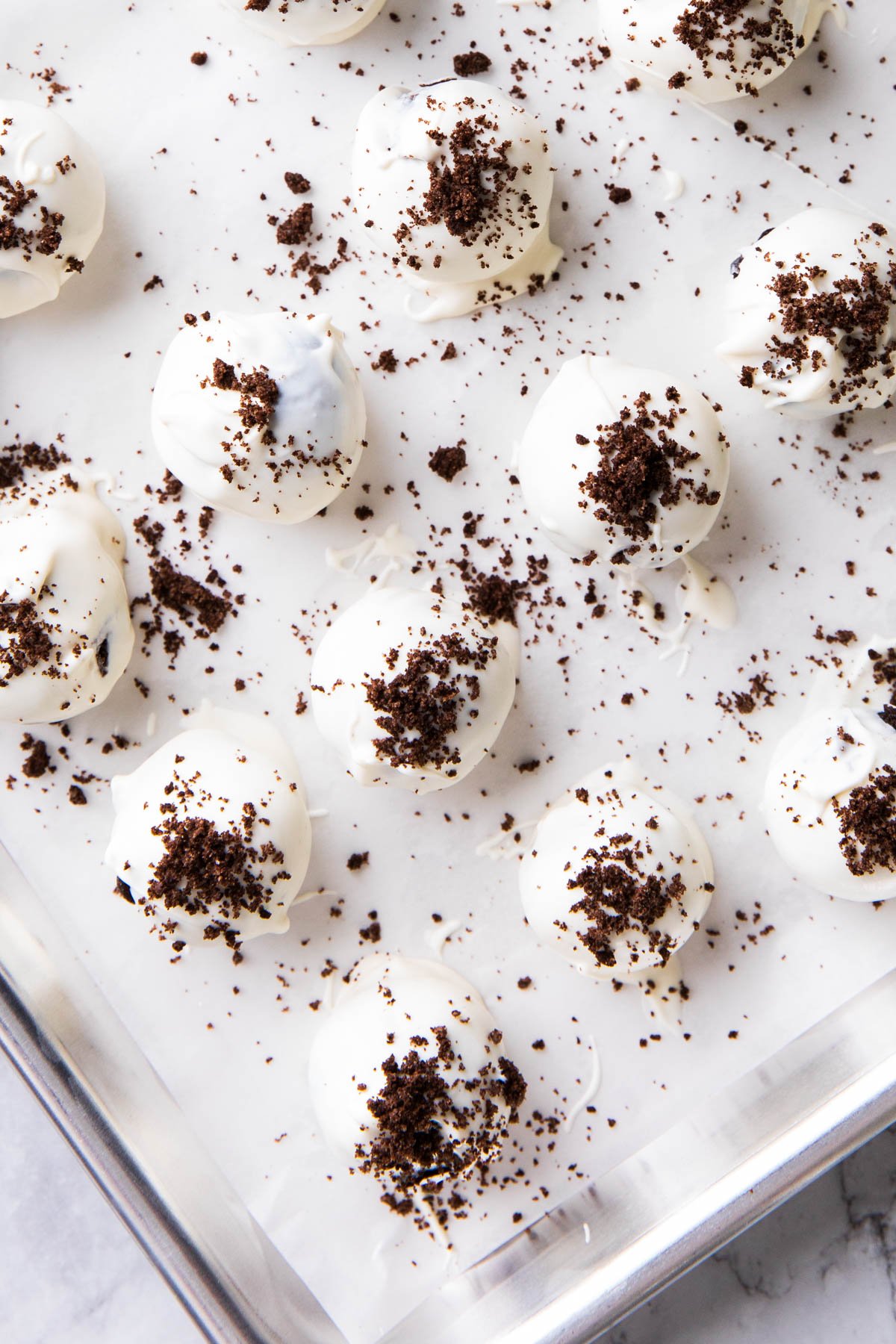 Oreo balls with cream cheese on a baking sheet, ready to be served for Christmas.