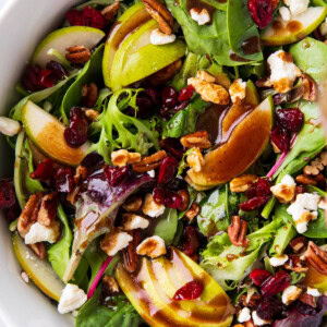 Pear Salad with balsamic dressing drizzled over lettuce, pears, cranberries, pecans, and feta cheese
