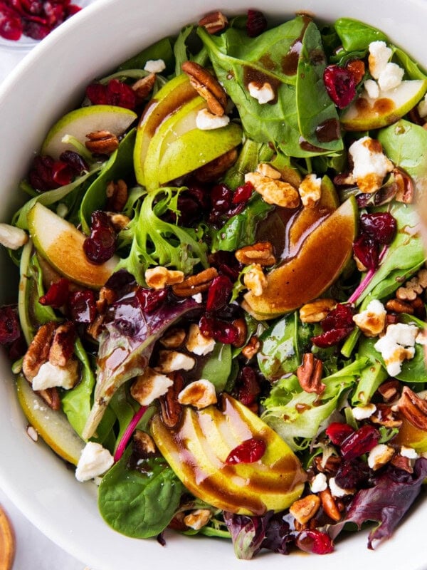 Pear Salad with balsamic dressing drizzled over lettuce, pears, cranberries, pecans, and feta cheese