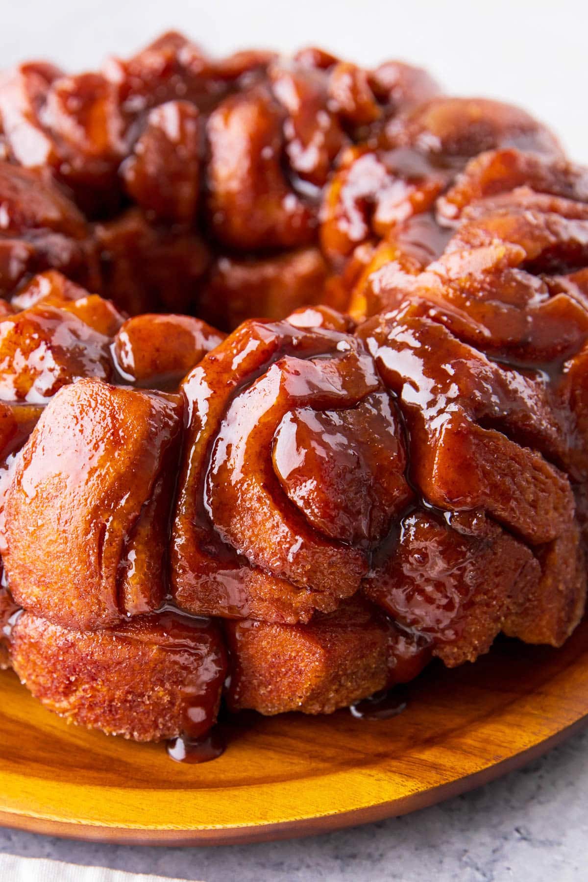 Close up of easy cinnamon roll monkey bread shows refrigerated cinnamon roll pieces baked together with cinnamon sugar and a brown sugar and butter.