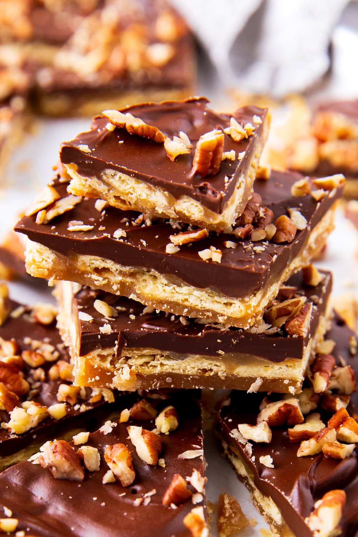 Close up stack of Saltine Cracker Toffee shows the toffee covered cracker and chocolate pecan layers of this homemade candy.