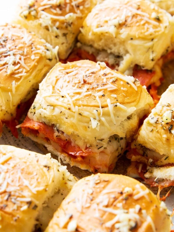 Fresh-baked pepperoni pizza sliders with Hawaiian rolls are packed with mozzarella cheese, pizza sauce, and garlic for an easy game day appetizer