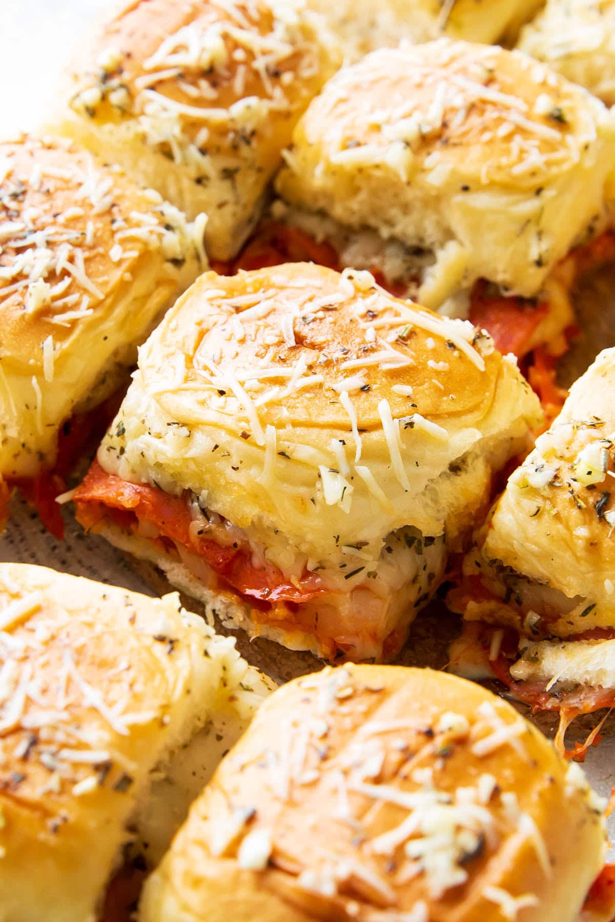 Fresh-baked pepperoni pizza sliders with Hawaiian rolls are packed with mozzarella cheese, pizza sauce, and garlic for an easy game day appetizer.
