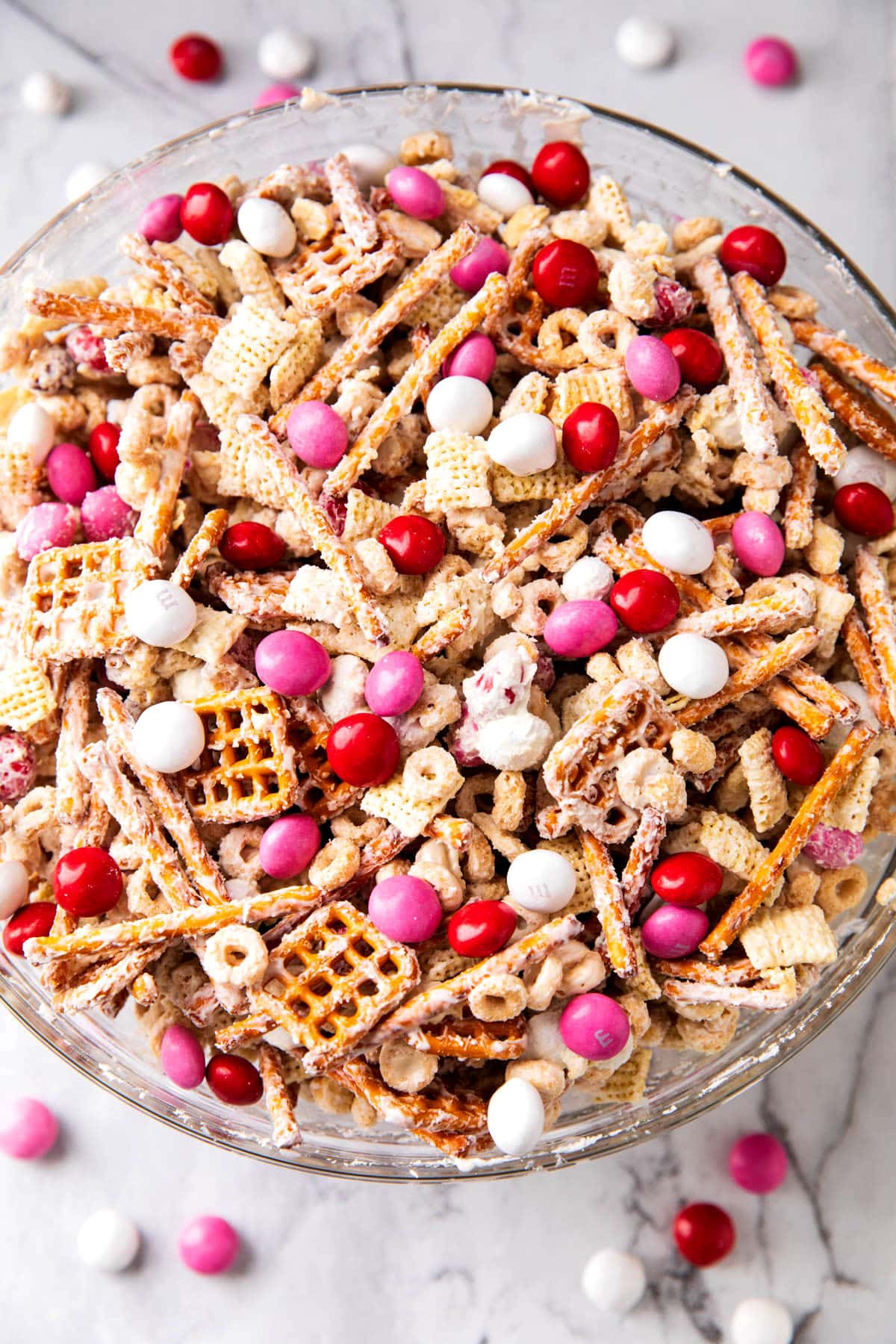 Valentines Chex mix served in a large serving bowl ready for snacking with crunchy cereal pieces and candy-coated chocolate.