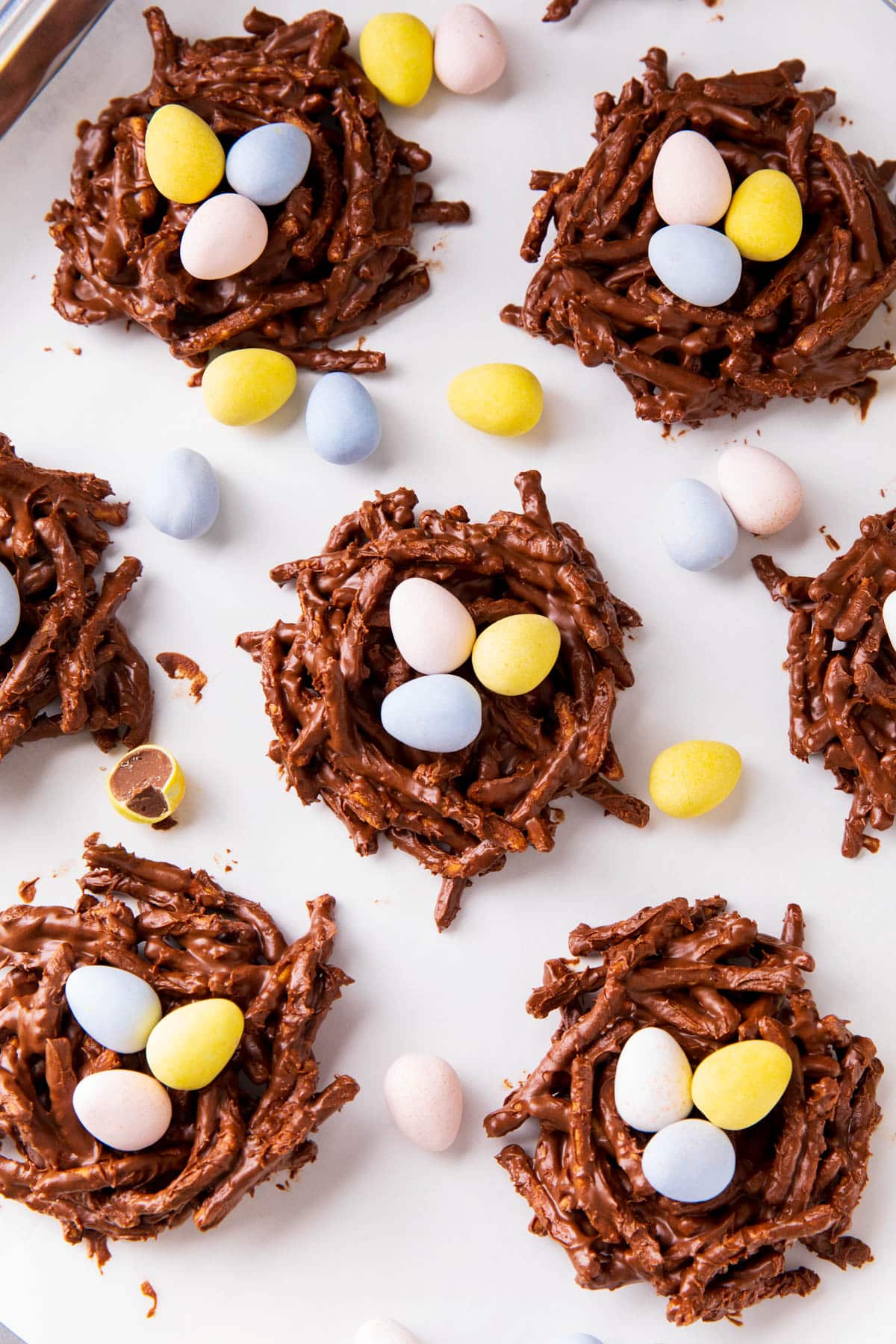 No bake chocolate birds nest cookies are placed close together to show crunchy, chocolate coated chow mein noodles and chocolate mini Easter eggs.