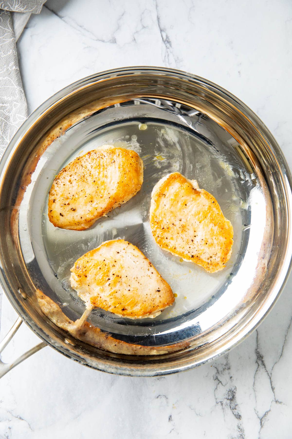 A photo showing How to Make Garlic Parmesan Chicken Pasta - cooked chicken on a skillet.