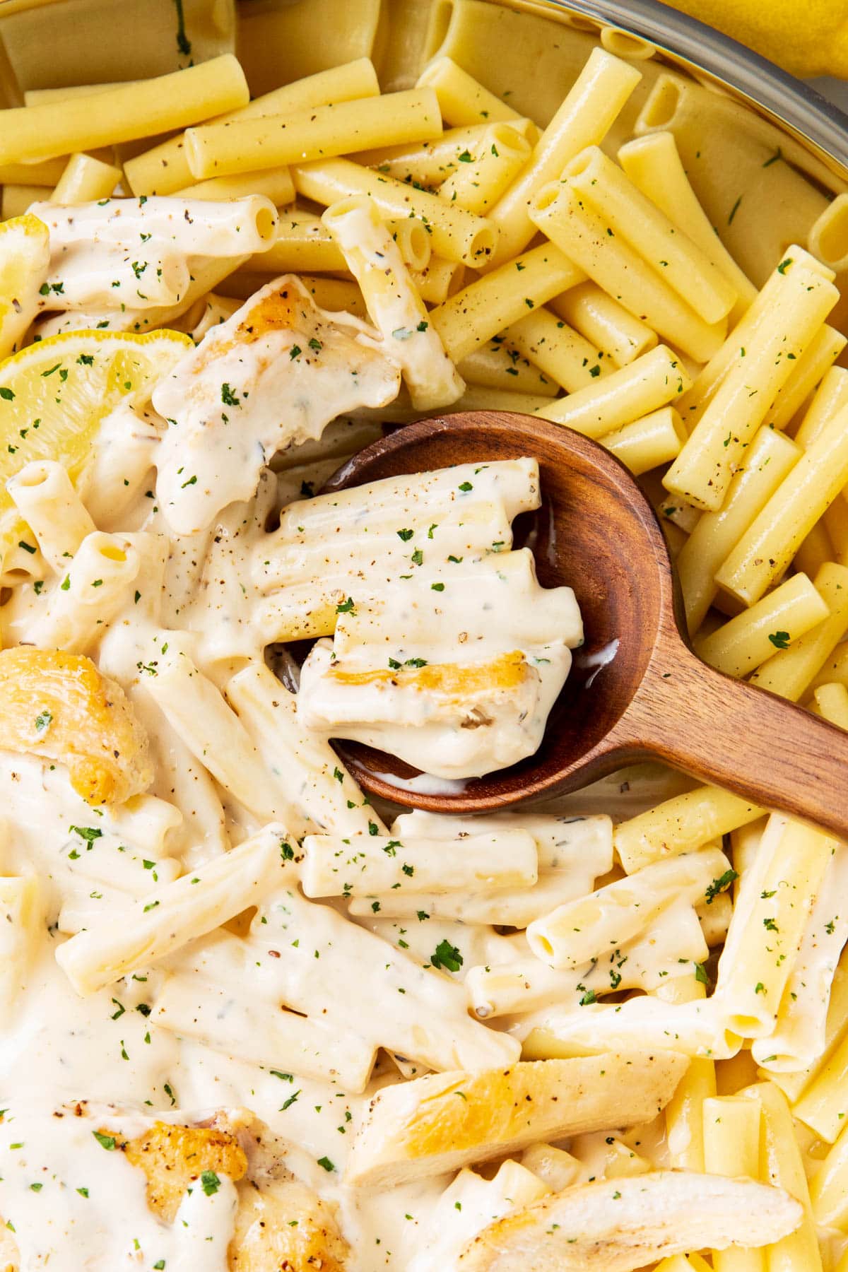 Close up of chicken garlic parmesan pasta to show rich pasta sauce coating sliced chicken tossed with pasta in this Italian dinner recipe.