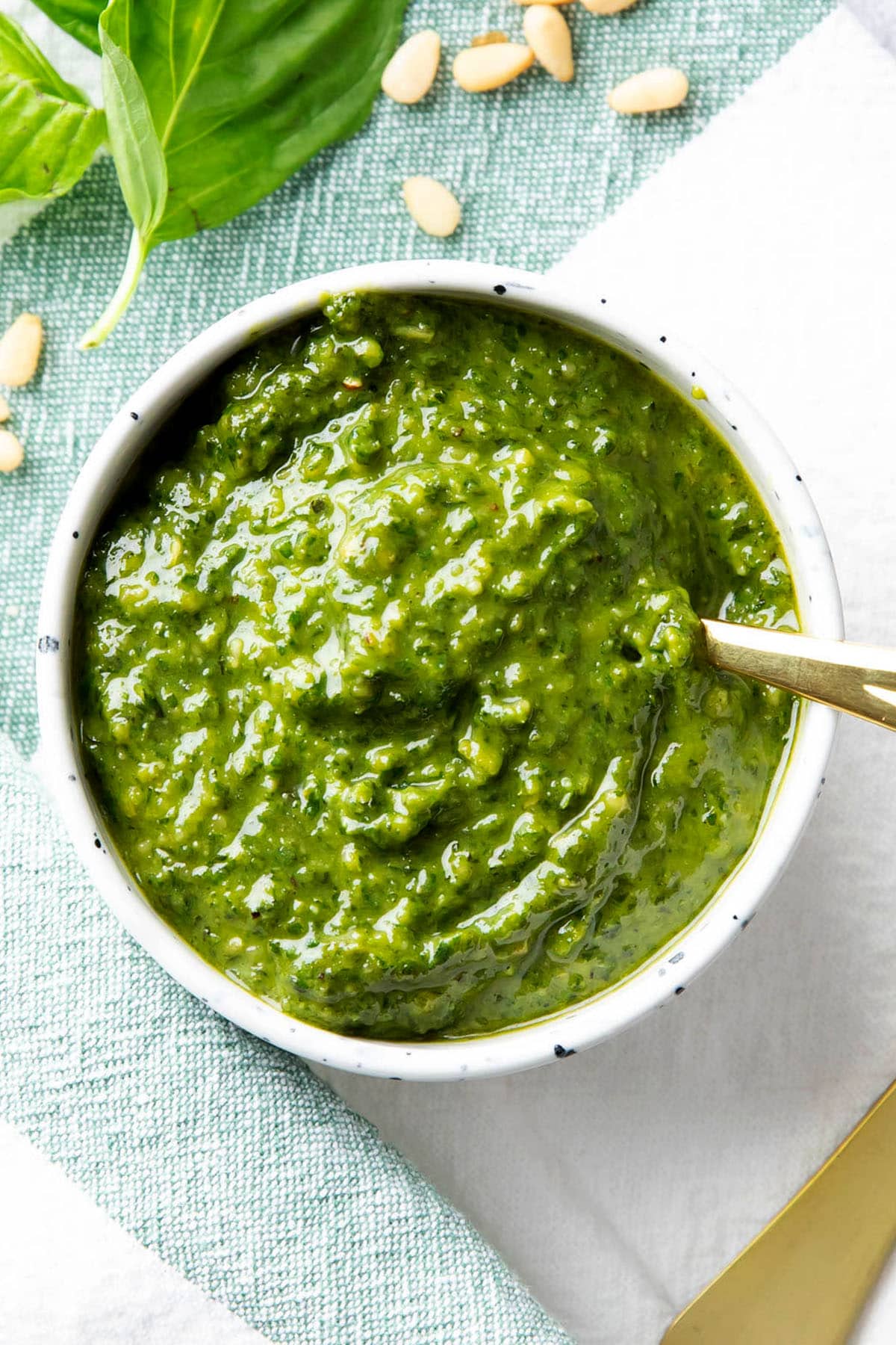 Serving this recipe for homemade pesto sauce in a condiment bowl with a spoon to add onto pasta, sandwiches, pizza, chicken and more.