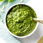Homemade basil pesto sauce is packed with fresh basil, pine nuts, and parmesan, served in a bowl