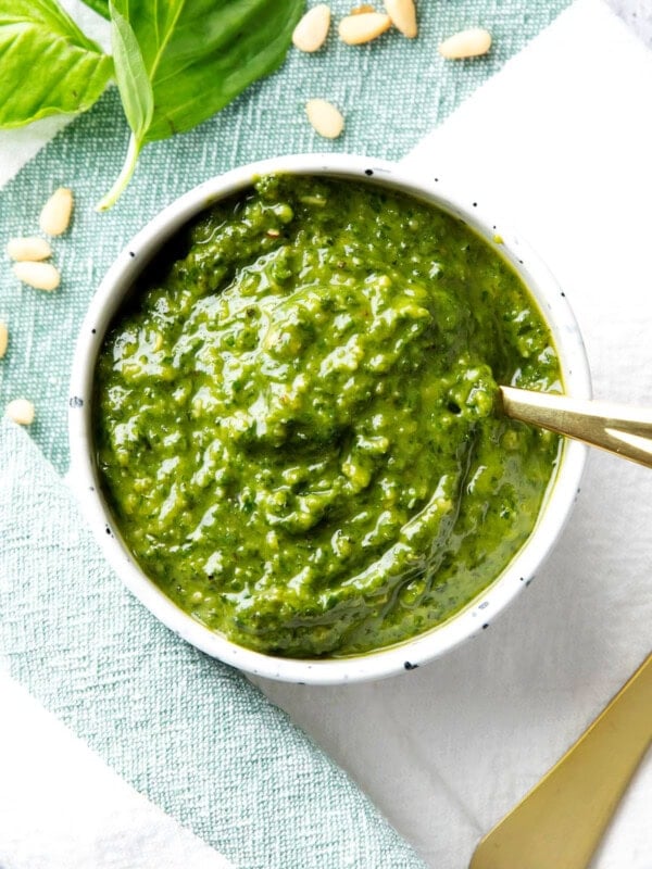 Homemade basil pesto sauce is packed with fresh basil, pine nuts, and parmesan, served in a bowl