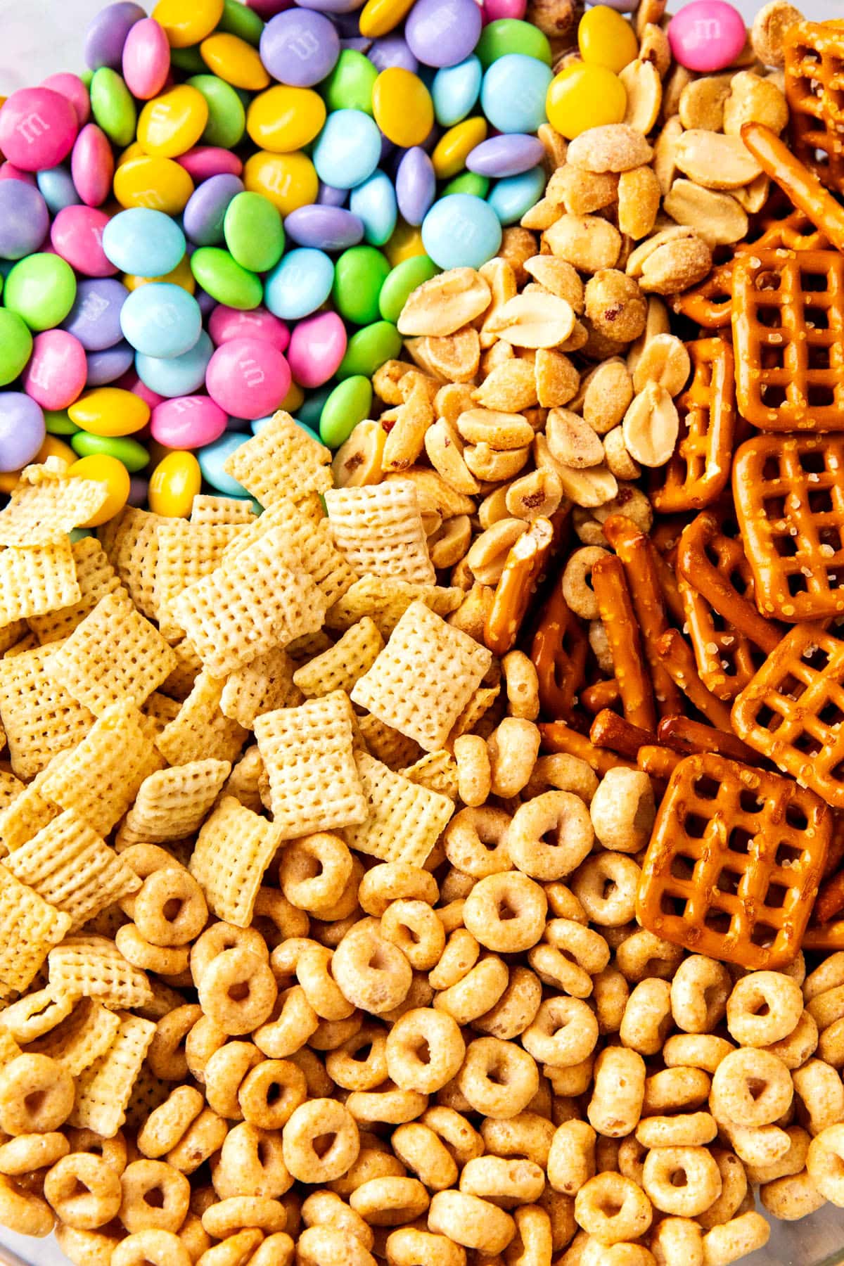 Close up of Bunny bait recipe dry mix including Chex cereal, pretzels, Easter M&M's candies, Cheerios and peanuts.