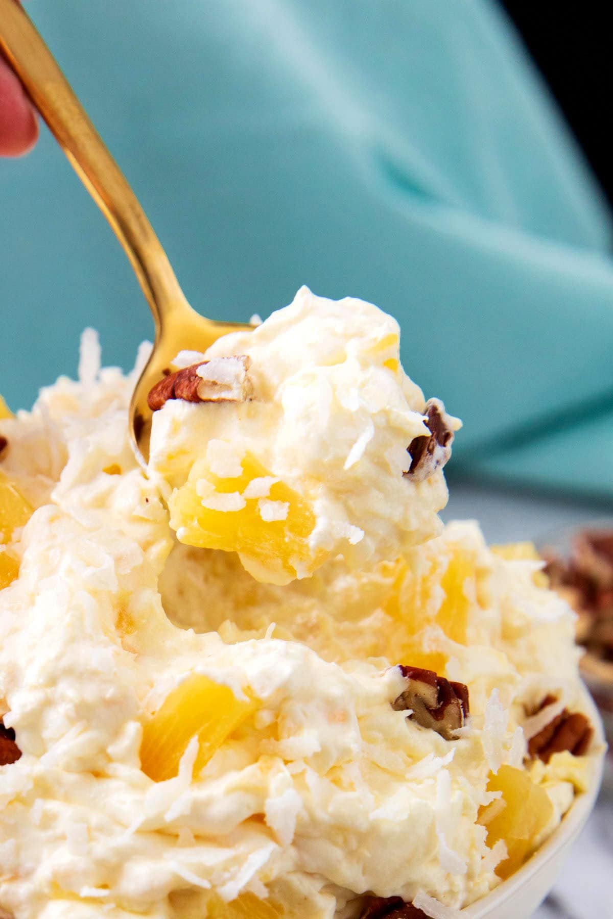 Someone spooning this recipe for pineapple fluff from a dessert bowl.